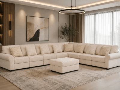 Brancaster beige corner sofa with decorative cushions and matching upholstered ottoman in a modern living room